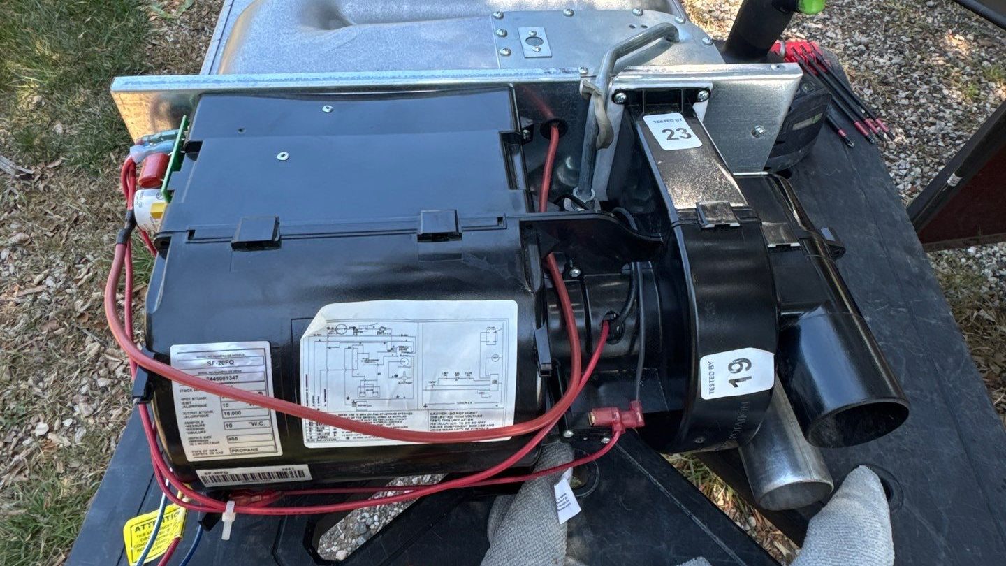 A Suburban RV furnace opened up on a work table during a service call