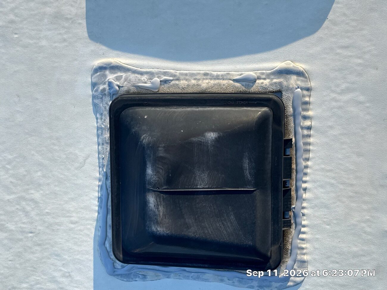 RV roof vent resealed with fresh white lap sealant
