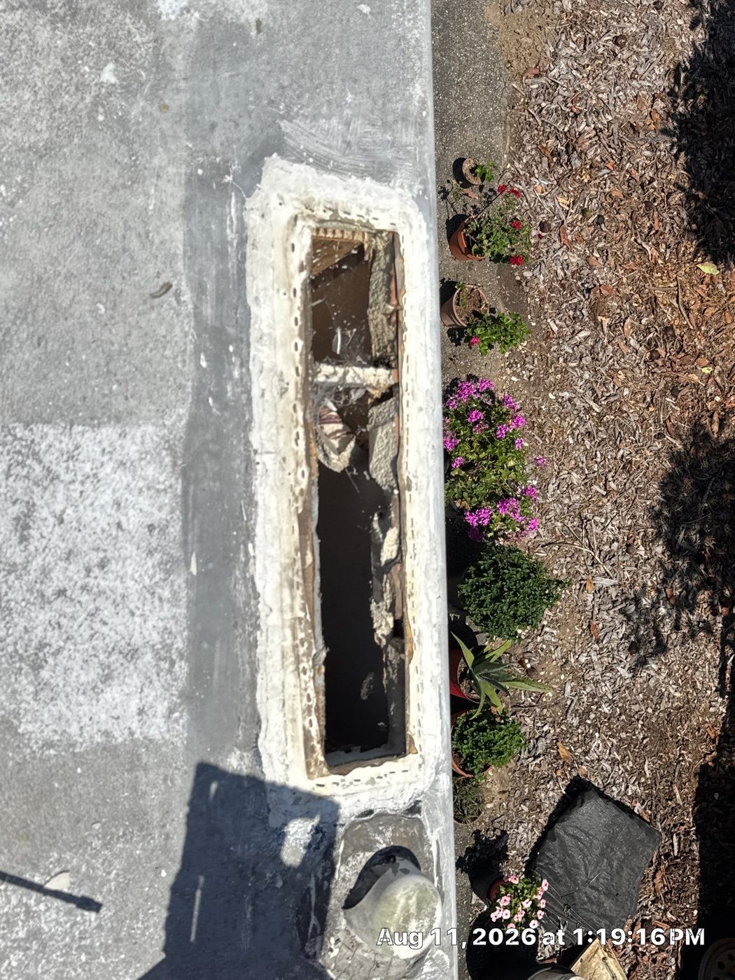 Water-rotted wood decking exposed beneath a removed RV roof vent, the result of a long-neglected roof leak